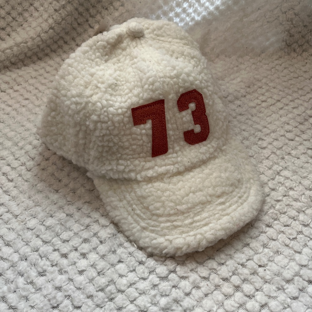 White and pink soft fashion hat with 73 displayed on front and tie back